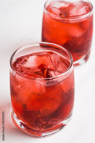 Red cocktail with cherry on the wooden background