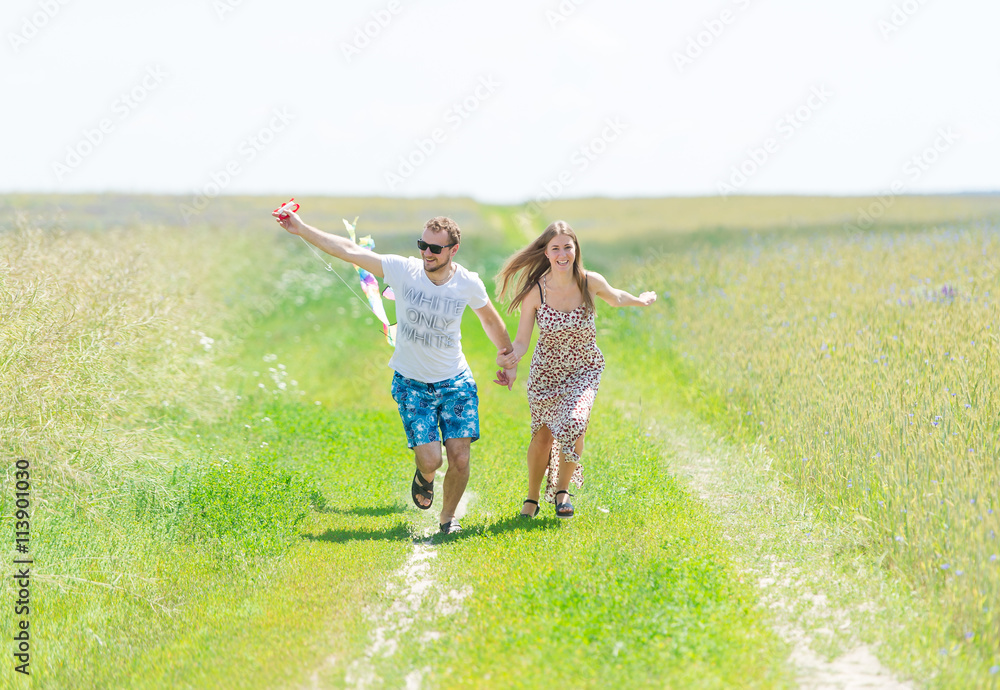 loving couple are fling kite on a meadow