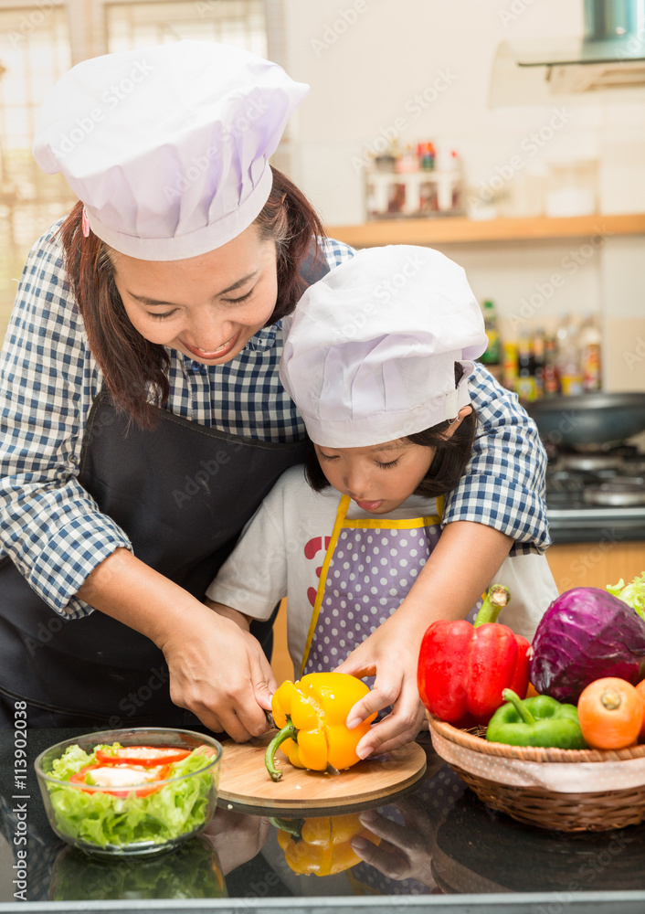 Asian mother teaching daughter making salad in kitchen,Cooking concept of happy asian little girl and mother making salad Asian mother teaching daughter making salad in kitchen,Cooking concept of happy asian little girl and mother making salad