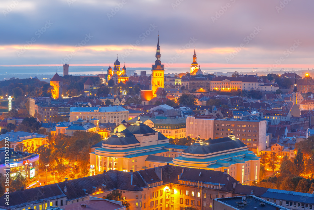 Aerial cityscape with Medieval Old Town illuminated at sunset with Saint Nicholas Church, Cathedral Church of Saint Mary and Alexander Nevsky Cathedral in Tallinn, Estonia