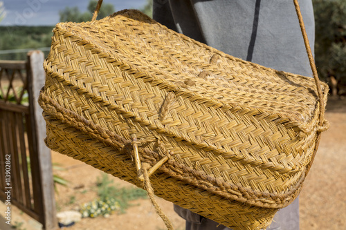 Detail of farm worker holding a traditional wicker basket used to keep the food, known in Andalusia as 