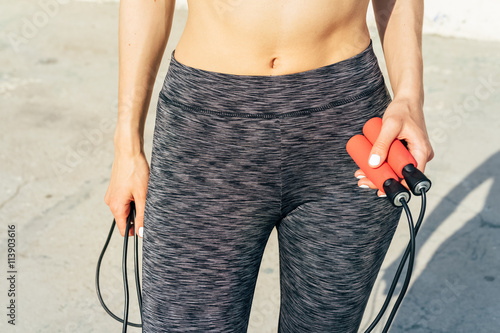 Cropped image of sports woman with a skipping rope in her hands