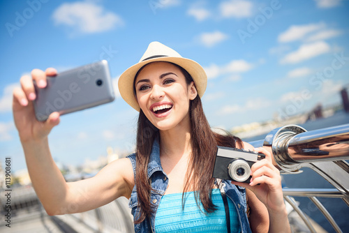 Joyful young girl photographing herself on telephone