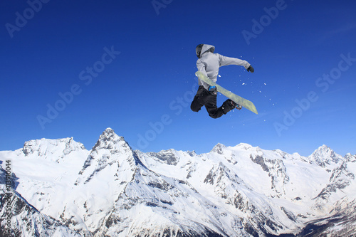 Snowboard rider jumping on mountains. Extreme snowboard freeride sport.