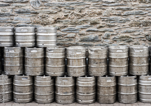 beer kegs stacked up in-front of brick wall