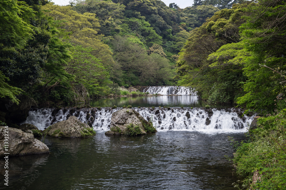 View of Cheonjiyeon River and two small cascades near Cheonjiyeon Falls on Jeju Island in South Korea.