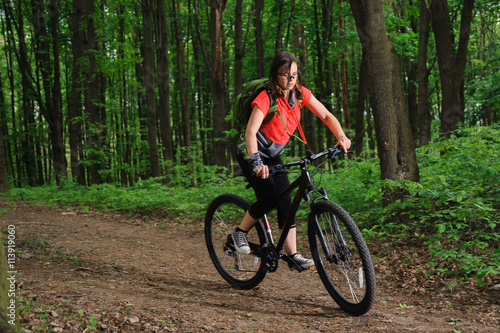 Girl riding a bike in the woods