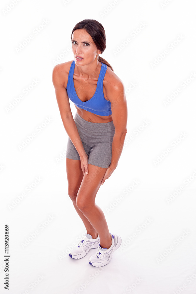 Cramping brunette woman holding her thigh Cramping brunette woman holding her thigh