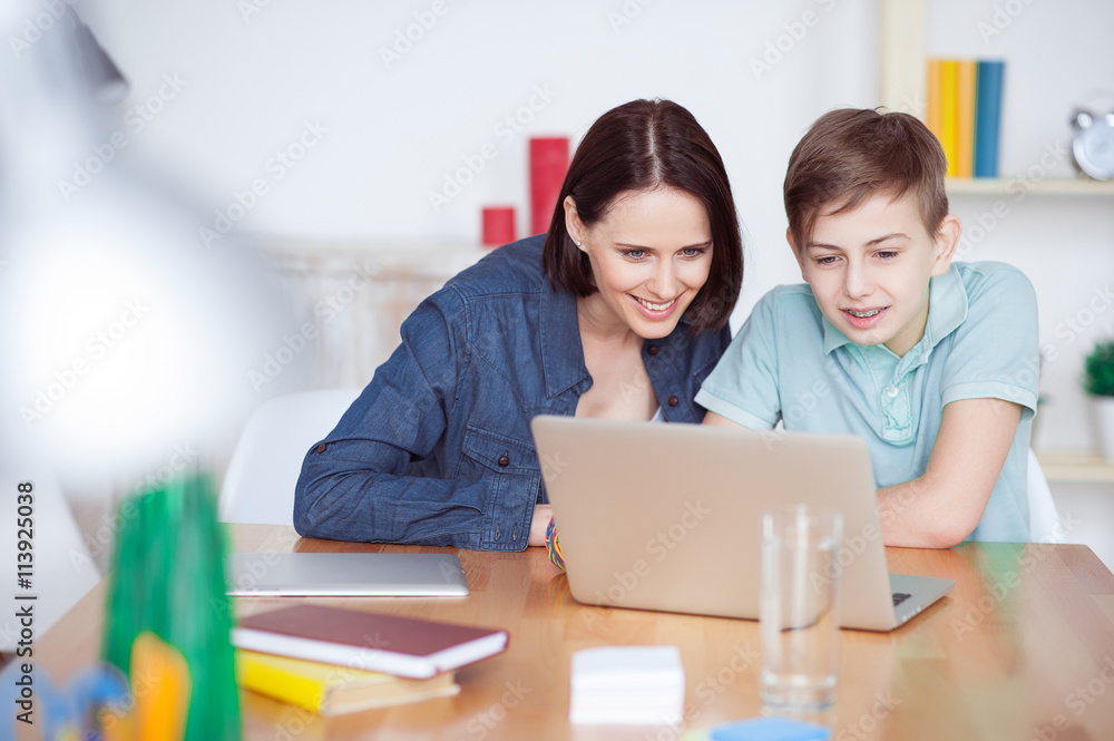 Happy mother helping his son to do homework Happy mother helping his son to do homework