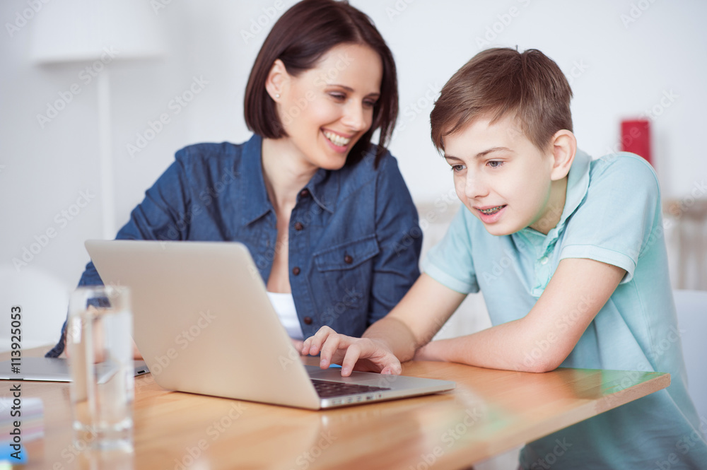 Happy mother helping his son to do homework Happy mother helping his son to do homework