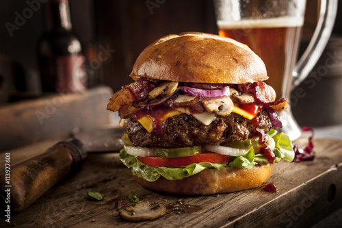 Large cheeseburger on bar with beer photo