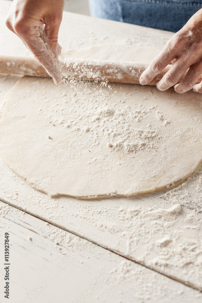 Sprinkling flour onto rolled out pastry Sprinkling flour onto rolled out pastry
