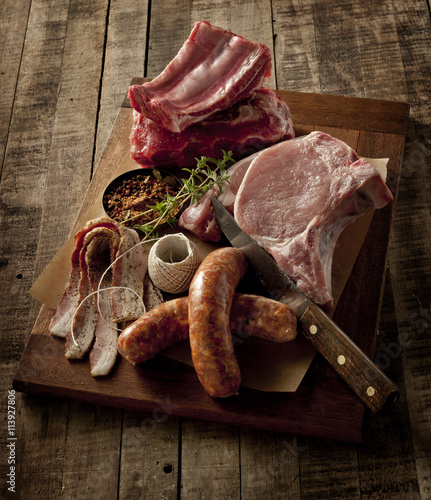 Wooden board with a selection of raw meats