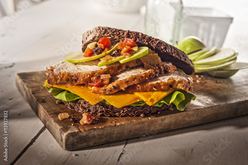 Huge chicken sandwich on wooden board