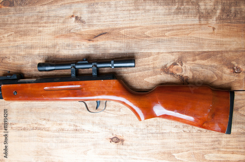 Air rifle isolated on wooden background