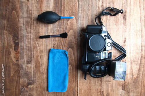 Old camera and cleaning equipment, on a wooden background