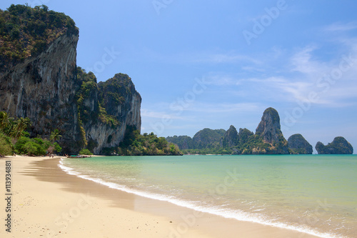 Beach with palm trees and rocks in the south of Thailand