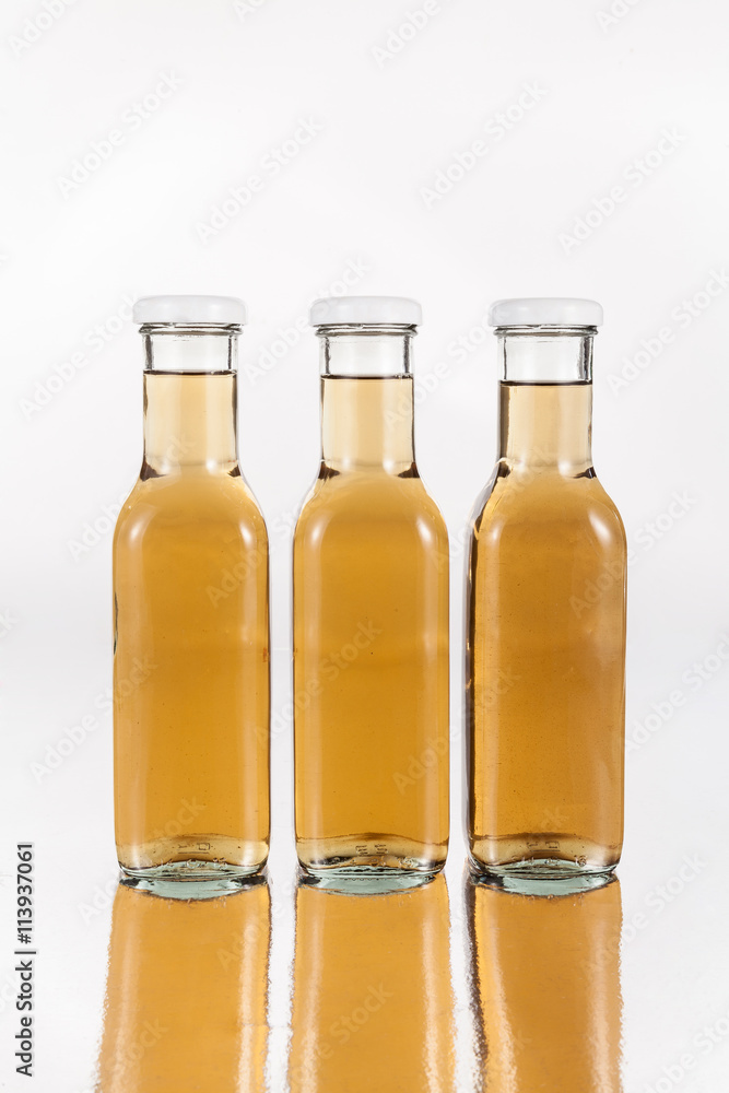 glass bottles with drink on neutral background