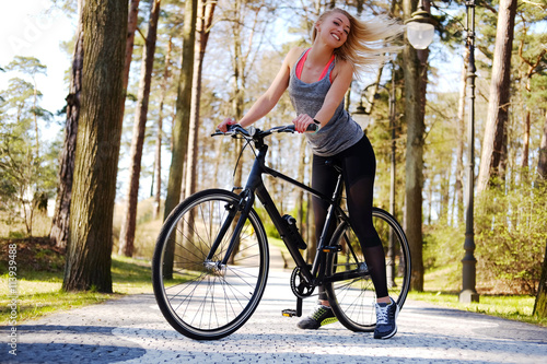 Female posing near bicycle.