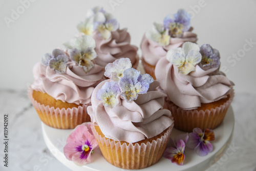 Purple almond coconut cupcakes with sugared edible flowers, ketogenic dessert 