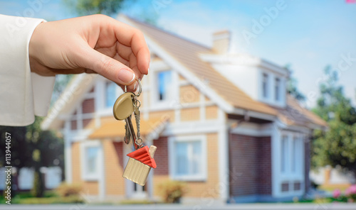 Keys in hands on house background