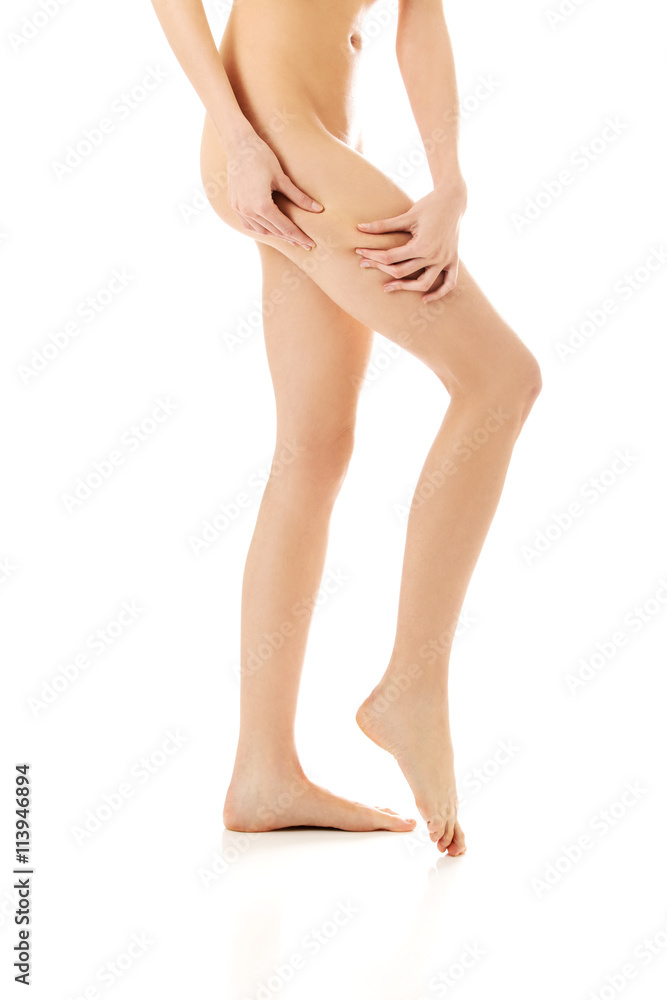 Female squeezes cellulite skin on her legs. Close-up shot on white background. Female squeezes cellulite skin on her legs. Close-up shot on white background.