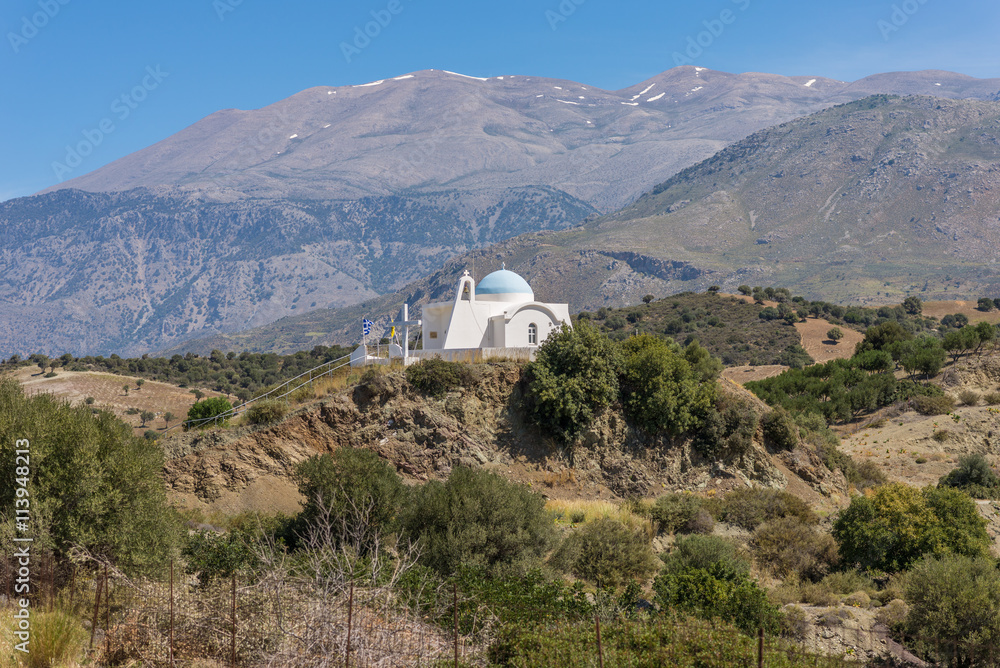 On the old road to Rethymno. White greek orthodox church in the foothills of the Ida Mountains on Crete. In the Background the Psiloritis, the highest mountain on Crete