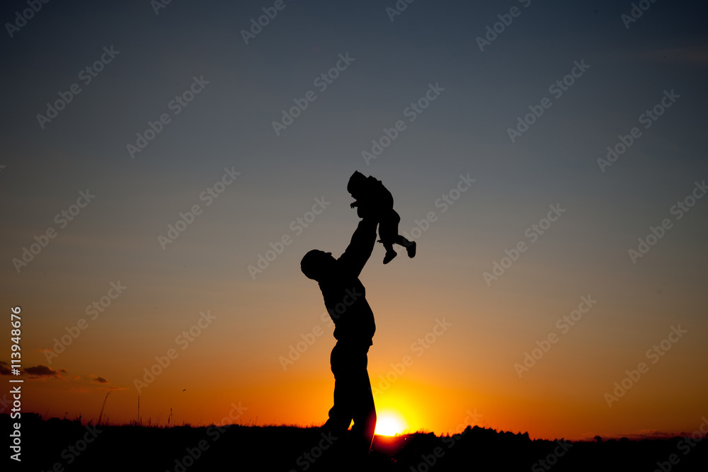 Father and child playing the sunset time. Concept of friendly family.