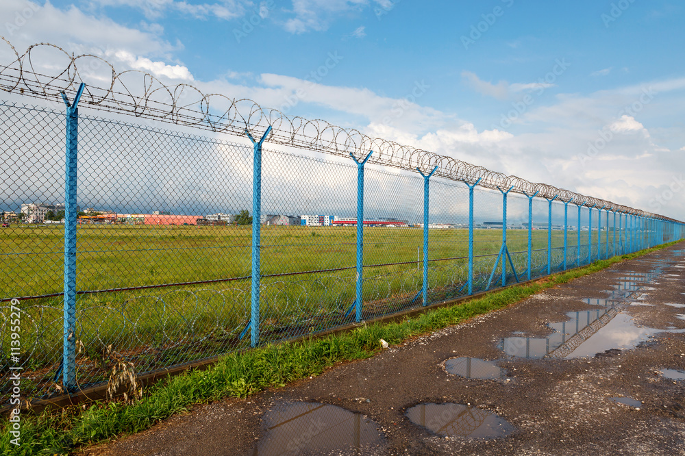 Barbed wire fence of a restricted area under blue sky