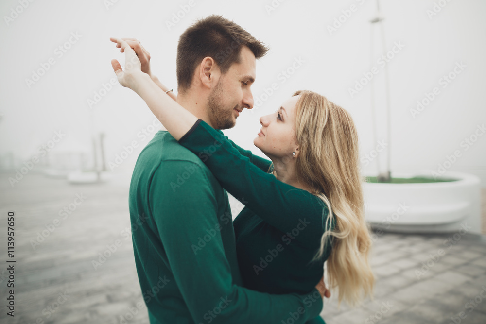 Lovely couple kissing and hugging on a sea dock