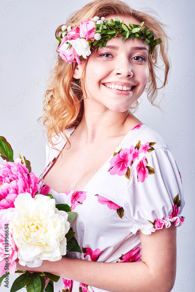 Beauty girl takes beautiful flowers in her hands. Blowing flower. Hairstyle with flowers. Fantasy girl portrait in pastel colors. Summer fairy portrait. Long permed hair. Beauty girl takes beautiful flowers in her hands. Blowing flower. Hairstyle with flowers. Fantasy girl portrait in pastel colors. Summer fairy portrait. Long permed hair.
