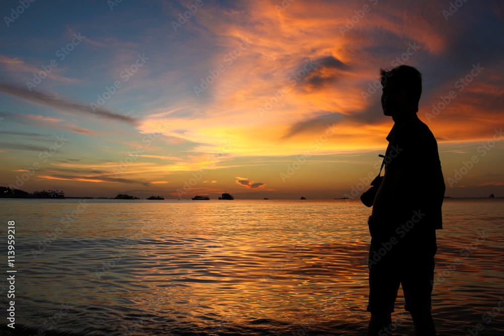 silhouette of photographer at sunset on the beach