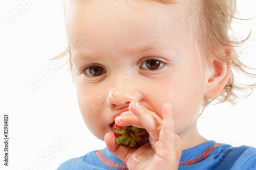 Portrait of a boy eating strawberries  on white background