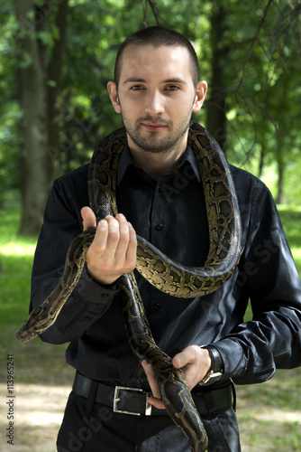 Young, handsome caucasian man with snake around his neck

