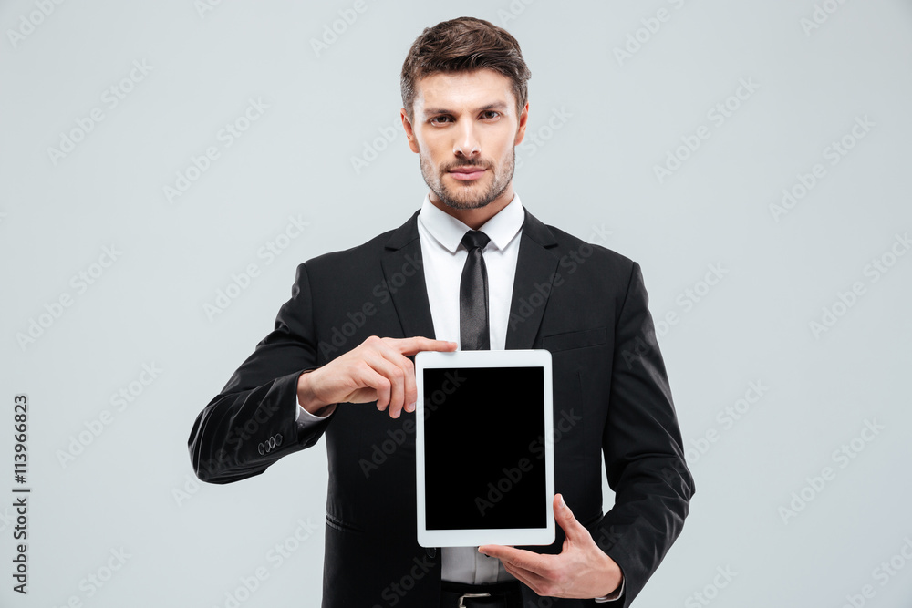 Handsome young businessman holding blank screen tablet