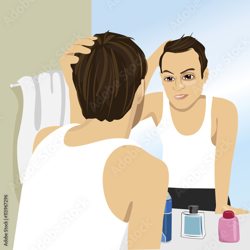 Young man worried about hair loss while looking in mirror