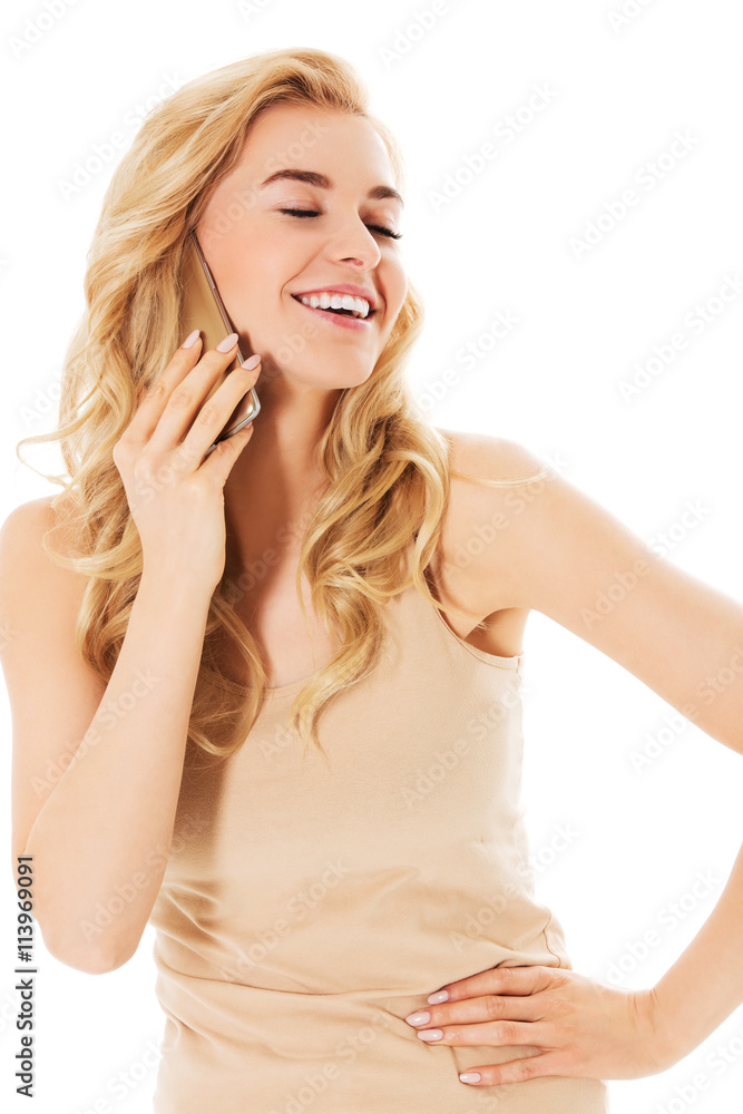 Fototapeta premium Young happy blonde woman talking through a smartphone