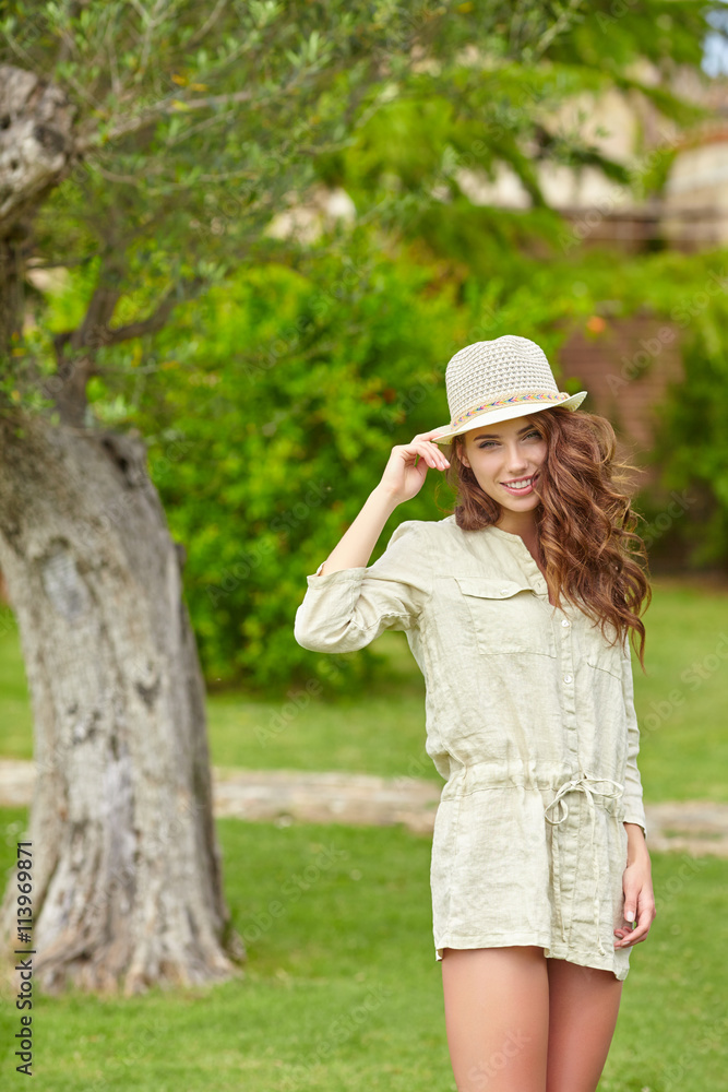 Smiling summer woman with hat  in italian garden