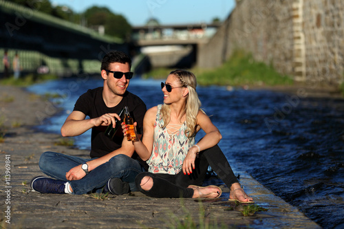 Photography Attractive young couple having a drink at a river