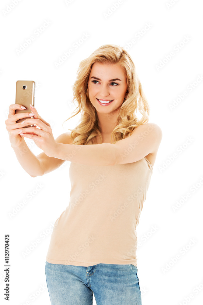 Happy young woman taking pictures of herself at smart phone Happy young woman taking pictures of herself at smart phone
