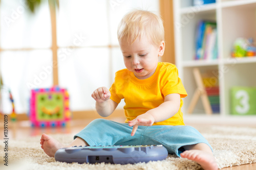 Happy kid boy playing piano...