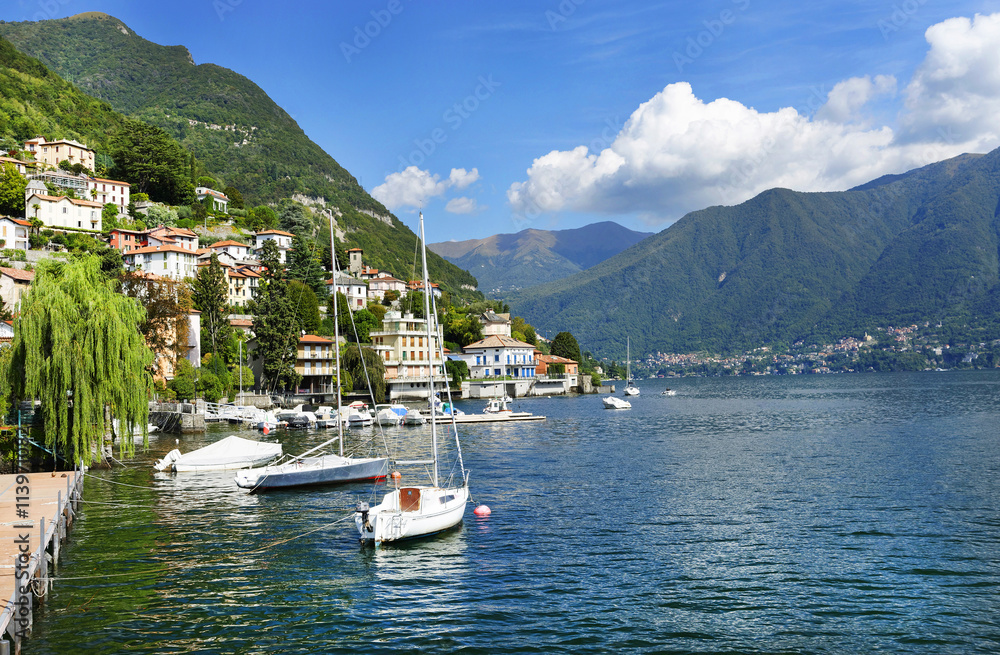 A beautiful day on lake Como in the romantic town  Moltrasio. Villas, sailboat and jetty. Italy, Europe, sept. 2015