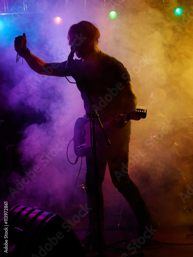 Silhouette of guitar player on stage.