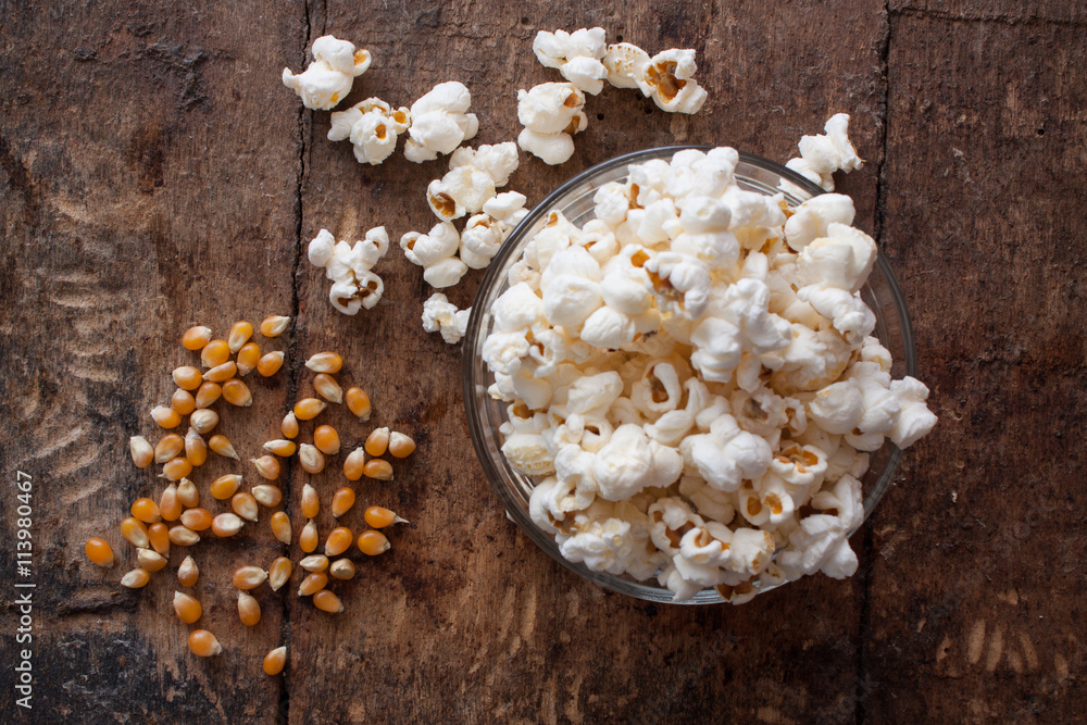 A bowl of popcorn on a wooden table A bowl of popcorn on a wooden table
