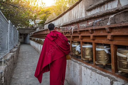  Monks rotating praying wheels in thetemple photo