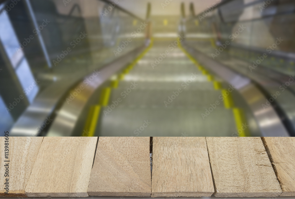 wood table top on blur background of escalator view wood table top on blur background of escalator view
