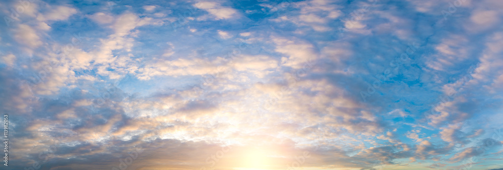 panorama of the sky during sunset or sunrise with cumulus clouds colored orange by the sun. panorama of the sky during sunset or sunrise with cumulus clouds colored orange by the sun.