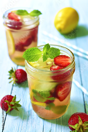 Strawberry lemonade with lemon and mint in a mason jar.