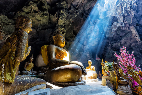 Amazing Buddhism with the ray of light in the cave © narathip12