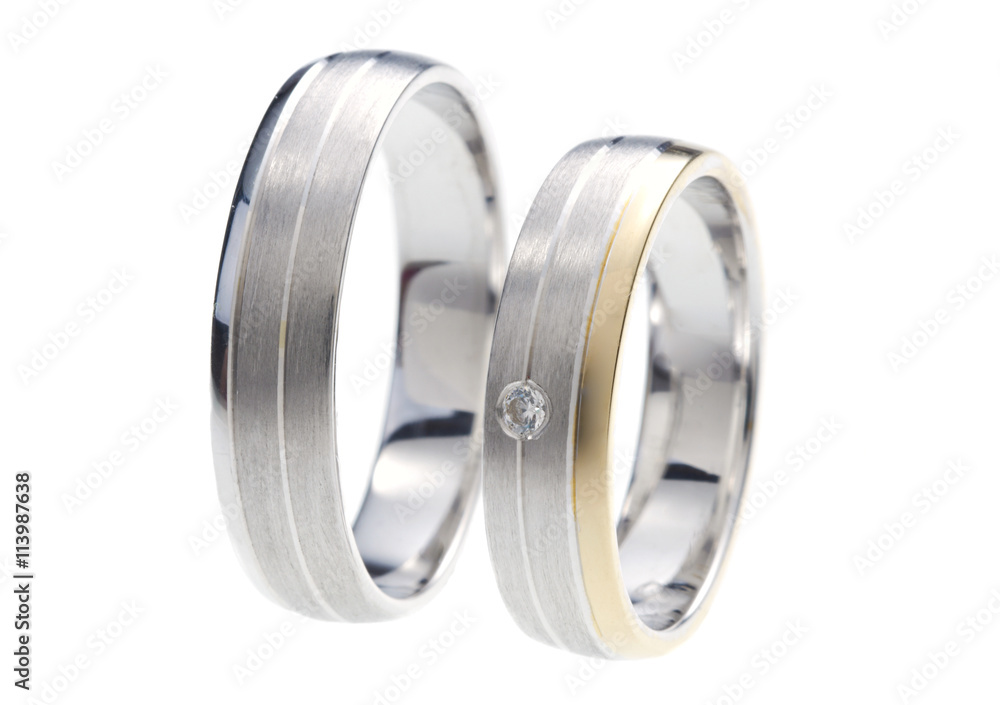 Two rings made of gold and white gold, one with diamond, isolated on white Two rings made of gold and white gold, one with diamond, isolated on white